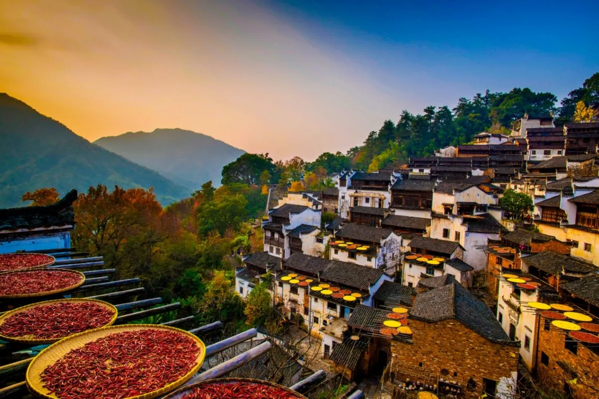 Dense cluster of rural village houses in China with chili peppers drying in the sun