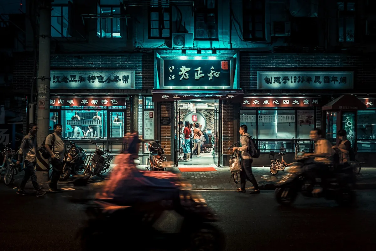 Busy city street at night with motorcycles and pedestrians
