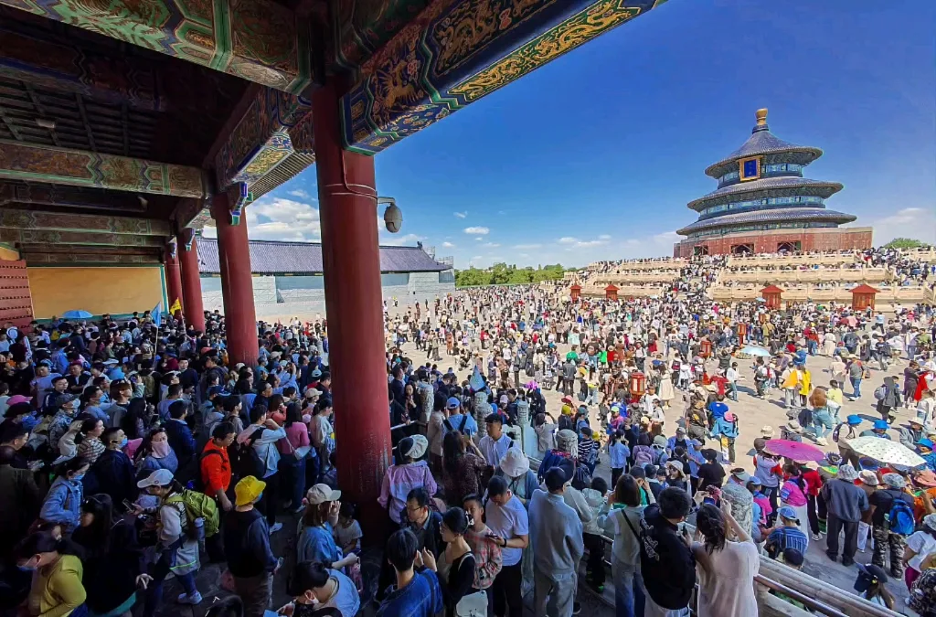 Foule rassemblée devant un grand bâtiment traditionnel chinois pendant la Golden Week