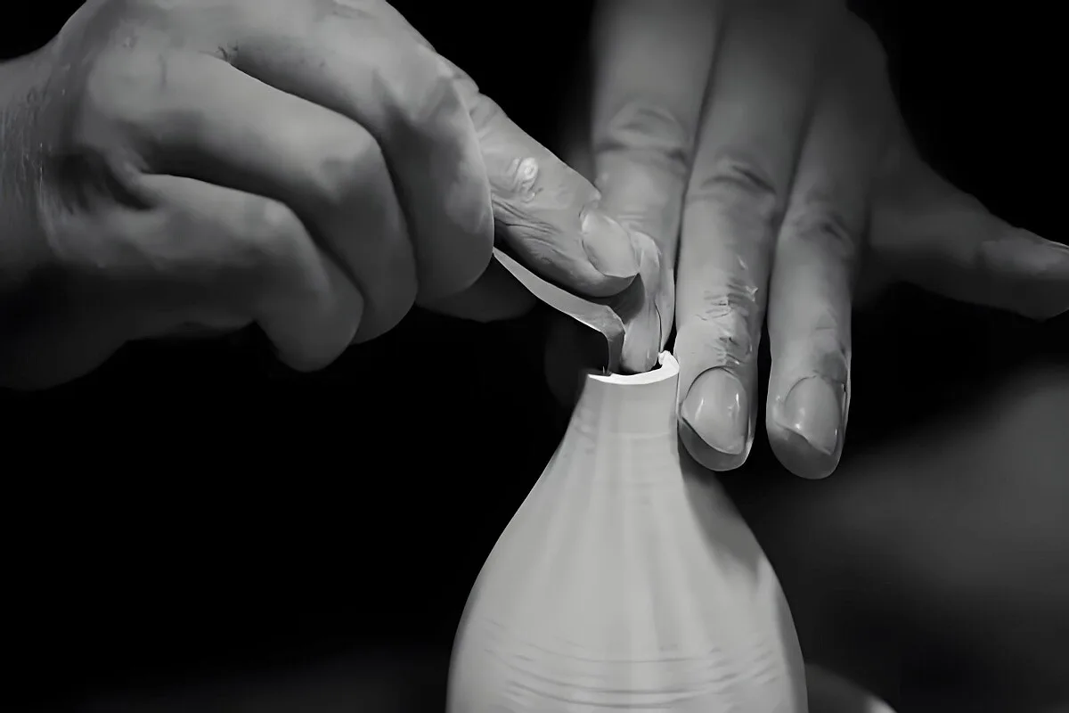 Traditional ceramic pottery workshop in Jingdezhen with artisan hands shaping clay