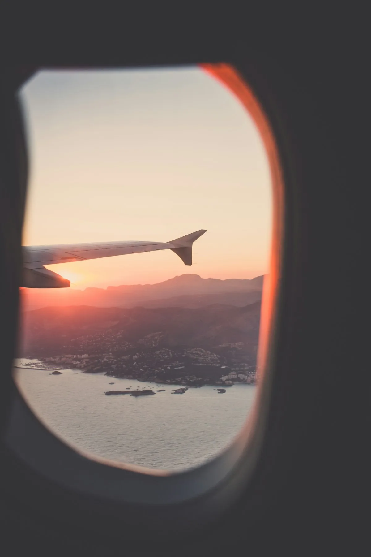 Airplane wing above clouds at sunset — seasonal travel to China