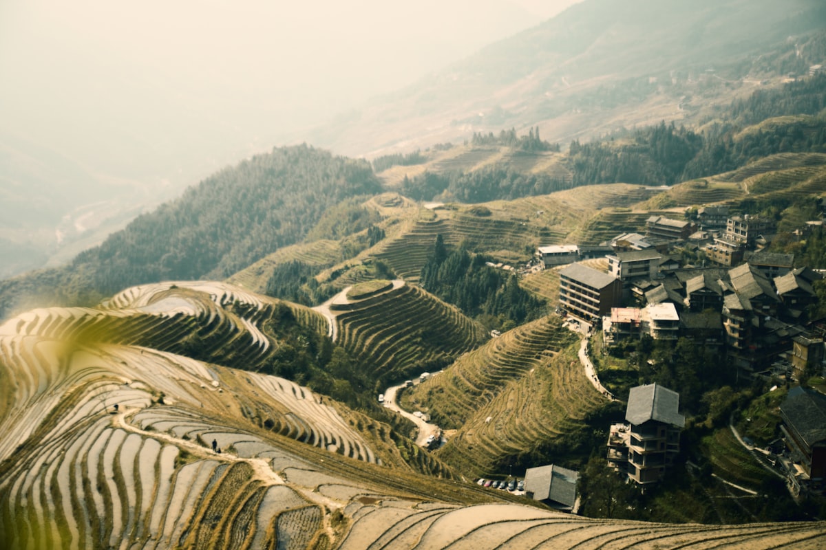 Aerial view of Longji Rice Terraces with water-filled paddies cascading down the mountainside