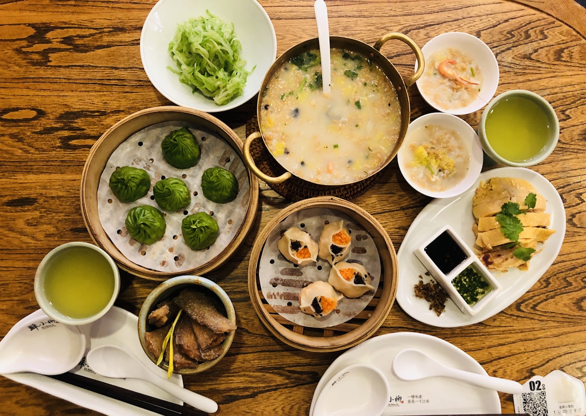 A lively spread of Chinese dishes — dumplings, noodles, stir-fries, and soups representing the diversity of China's Eight Great Cuisines