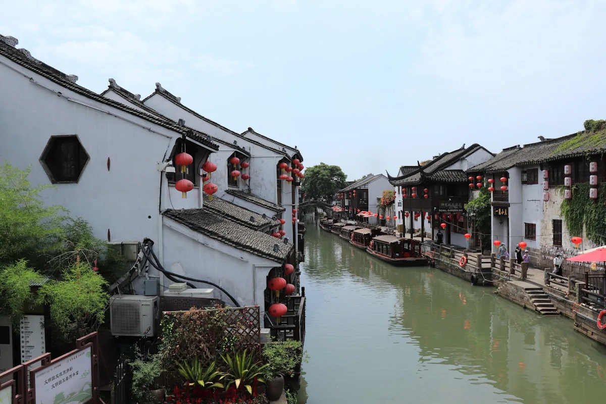 White and red boat floating on a peaceful canal in Suzhou ancient water town