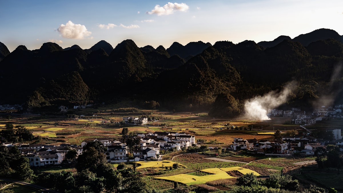 Rural village nestled among rolling hills at sunset in southern China