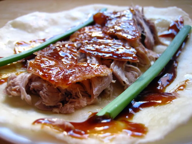 Un rollo de pato laqueado con cebolleta y salsa (Foto: joyosity via Wikimedia Commons)