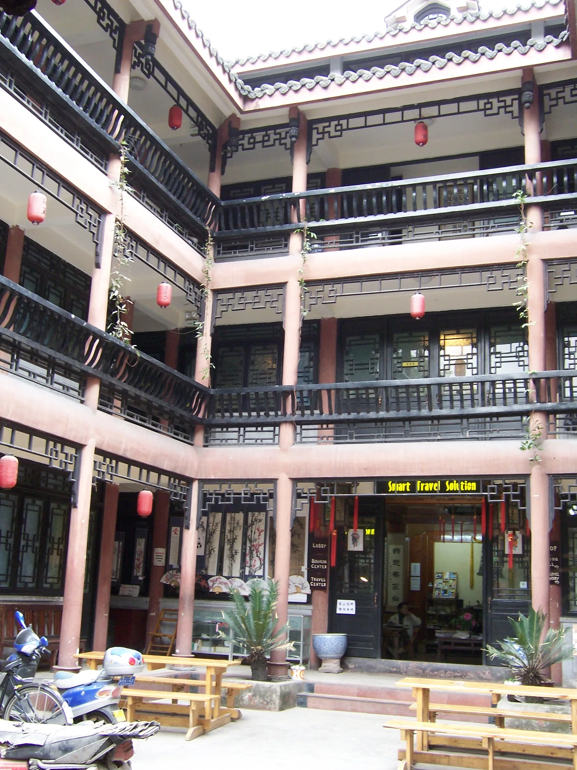 Courtyard of a small Chinese guesthouse hostel with red lanterns and wooden railings (Photo: McKay Savage via Wikimedia Commons)