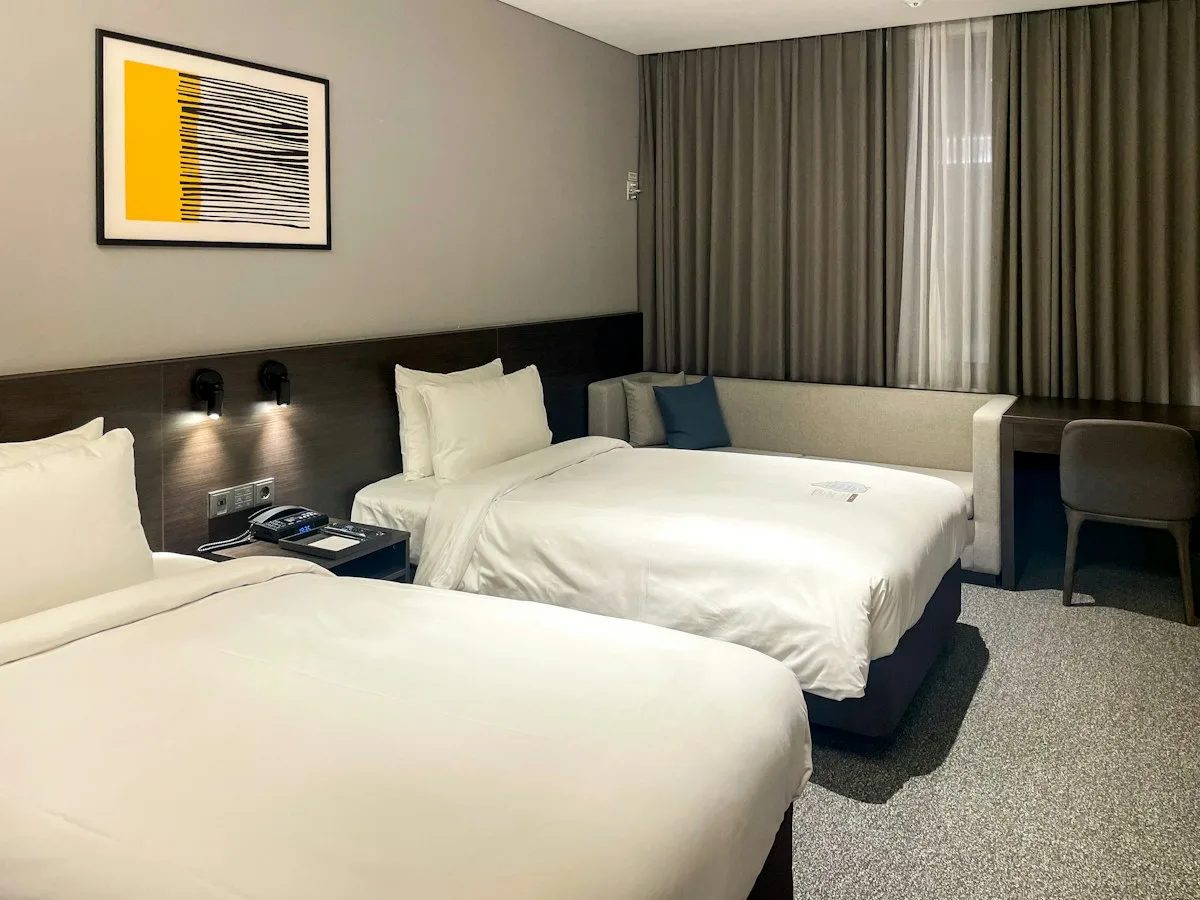 A simple twin hotel room with wooden headboards