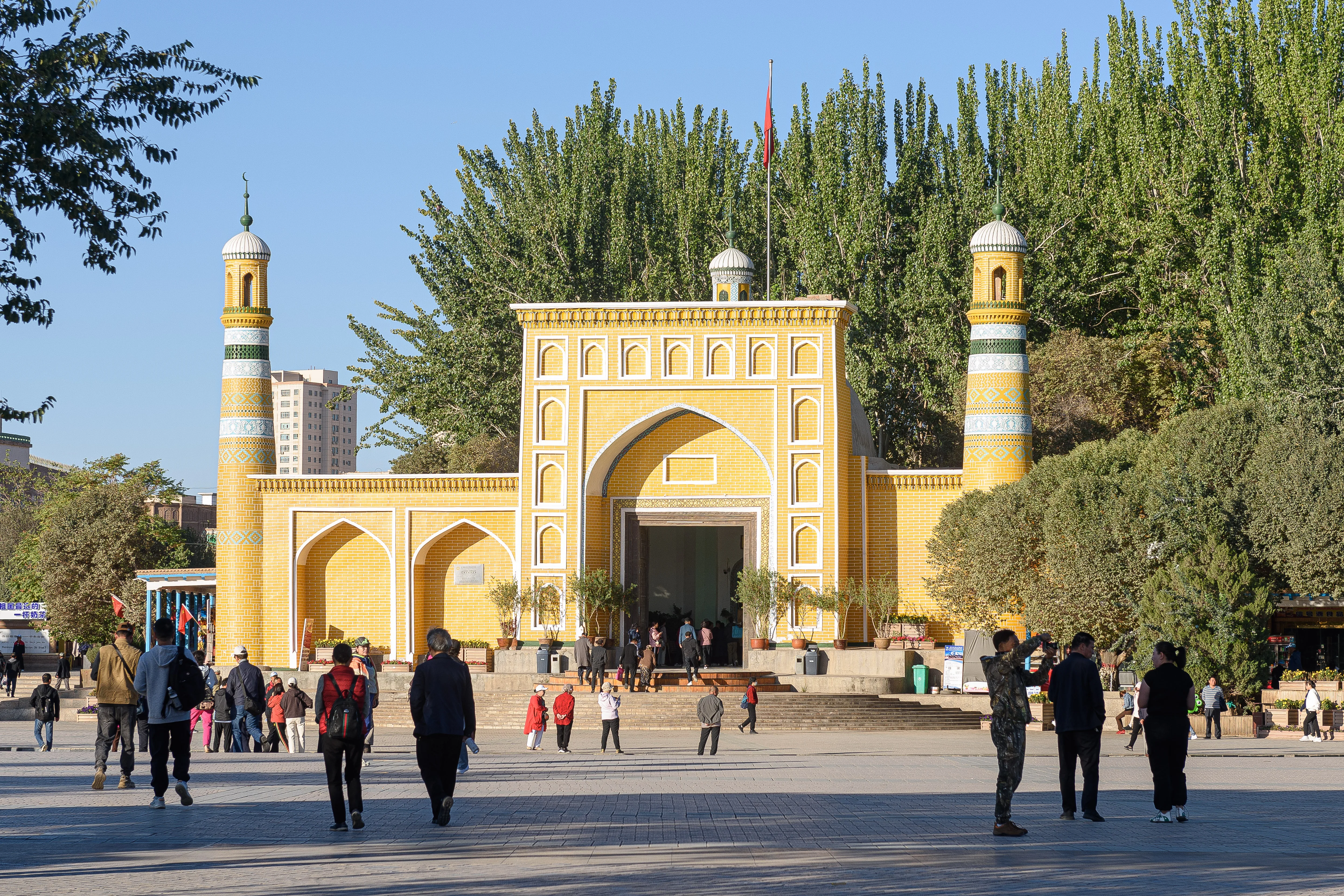 La mosquée Id Kah à Kachgar, au Xinjiang, avec sa façade de carreaux jaunes et ses deux minarets (Photo : N509FZ via Wikimedia Commons)