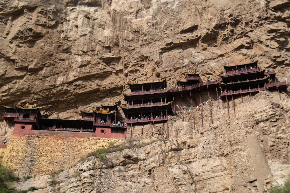 A mountain side with some buildings built into the side of it