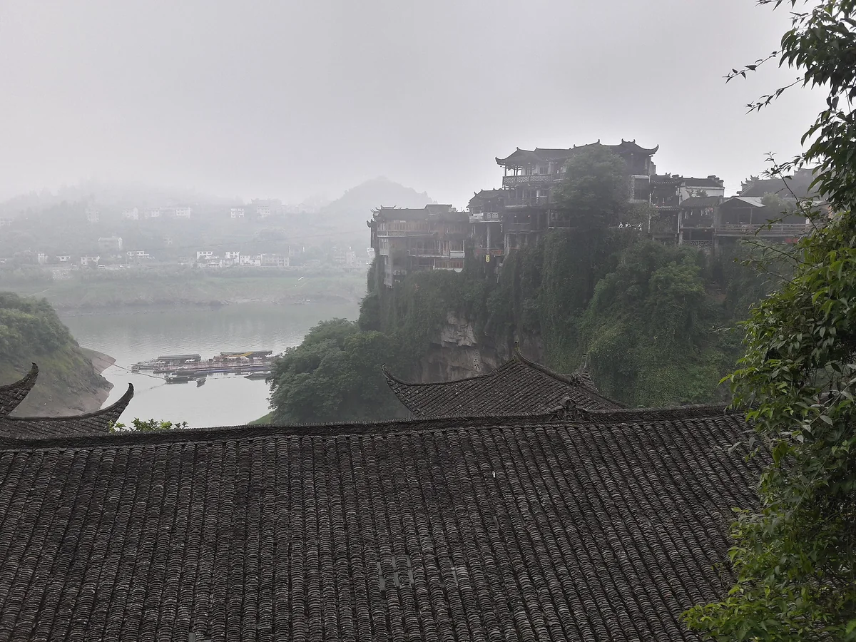 Morning mist in the gorge at Furong Town, with the stilt houses along the cliff edge emerging above the Youshui River (Photo: Popolon via Wikimedia Commons)