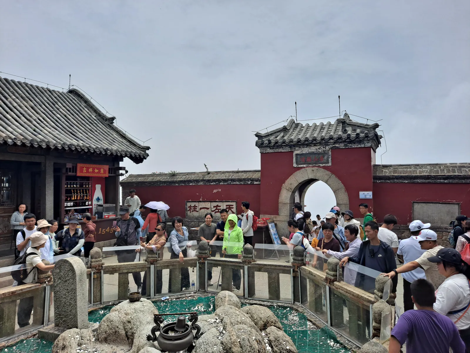 Crowds of visitors on the rocks below the temple and weather station on Jade Emperor Peak, the summit of Mount Tai, under a clear blue sky (Photo: H2v5o68z via Wikimedia Commons)