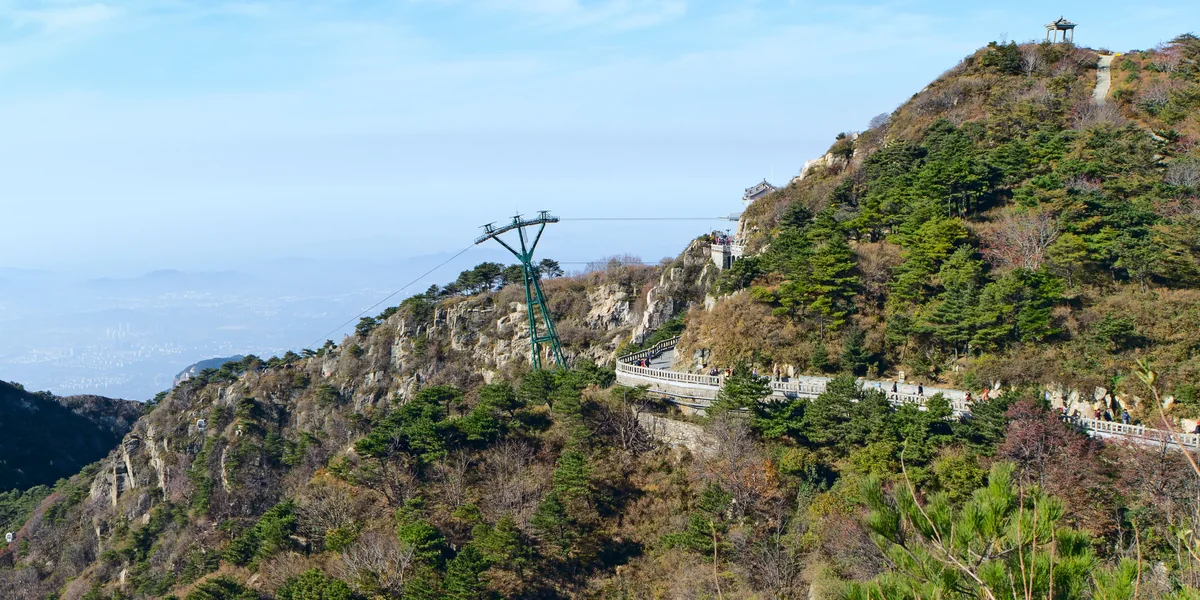 The cableway tower and the summit path cut into Mount Tai's ridge, with the Shandong plain visible far below (Photo: See-ming Lee via Wikimedia Commons)