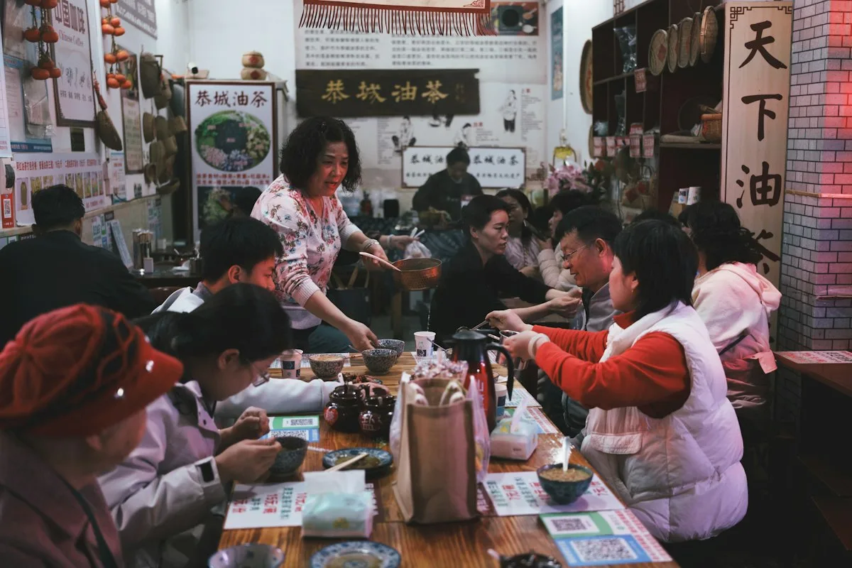 Diners sharing a long communal table at a Chinese oil tea shop