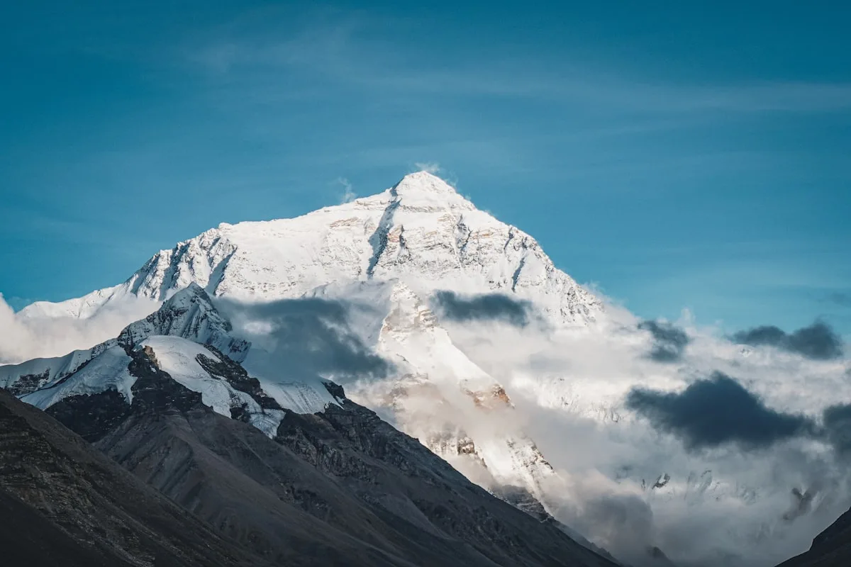 Des sommets himalayens enneigés au Tibet s'élevant au-dessus d'une mer de nuages