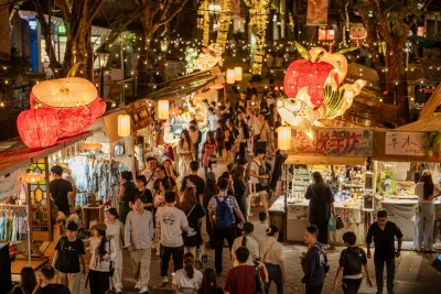 Crowded Chinese night market with food stalls and red lanterns