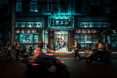 Busy city street at night with motorcycles and pedestrians