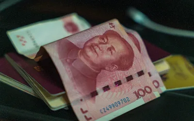 Chinese yuan banknotes on top of passports, planning a China trip budget