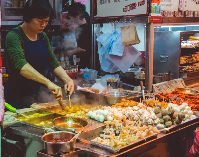 A woman cooking street food at a Chinese night market stall