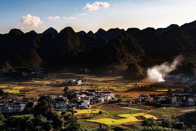 Rural village nestled among rolling hills at sunset in southern China