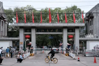 The west gate of Peking University with Chinese flags and red lanterns