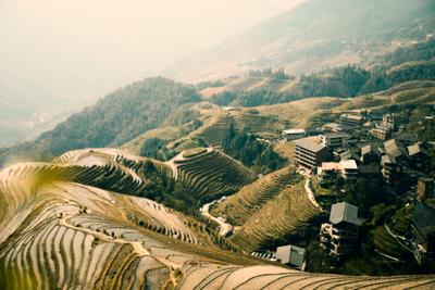 Aerial view of Longji Rice Terraces with water-filled paddies cascading down the mountainside