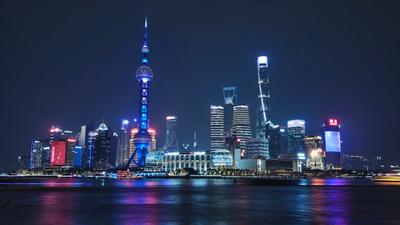 Shanghai skyline at night with lights reflecting on the Huangpu River